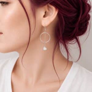 Boucles d'oreilles Calyssa en acier inoxydable argenté avec anneau et cœur suspendu.