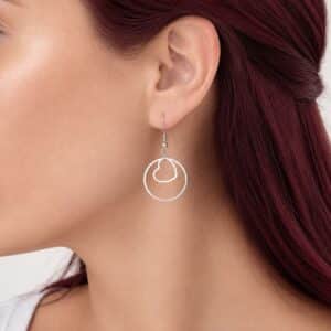 Boucles d'oreilles Carina en acier inoxydable argenté avec anneau et cœur suspendu.