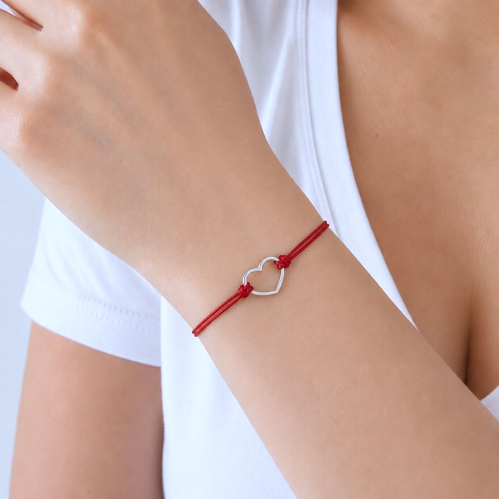 Bracelet Célia avec cœur en acier inoxydable argenté sur cordon rouge bordeaux ajustable.