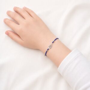 Bracelet enfant aile d'ange Amélia Minia en acier inoxydable argenté avec cordon bleu ajustable.