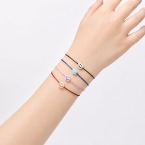 Bracelet enfant Smiley Lumineux Sofia Minia en acier inoxydable avec smiley phosphorescent et cordon ajustable.