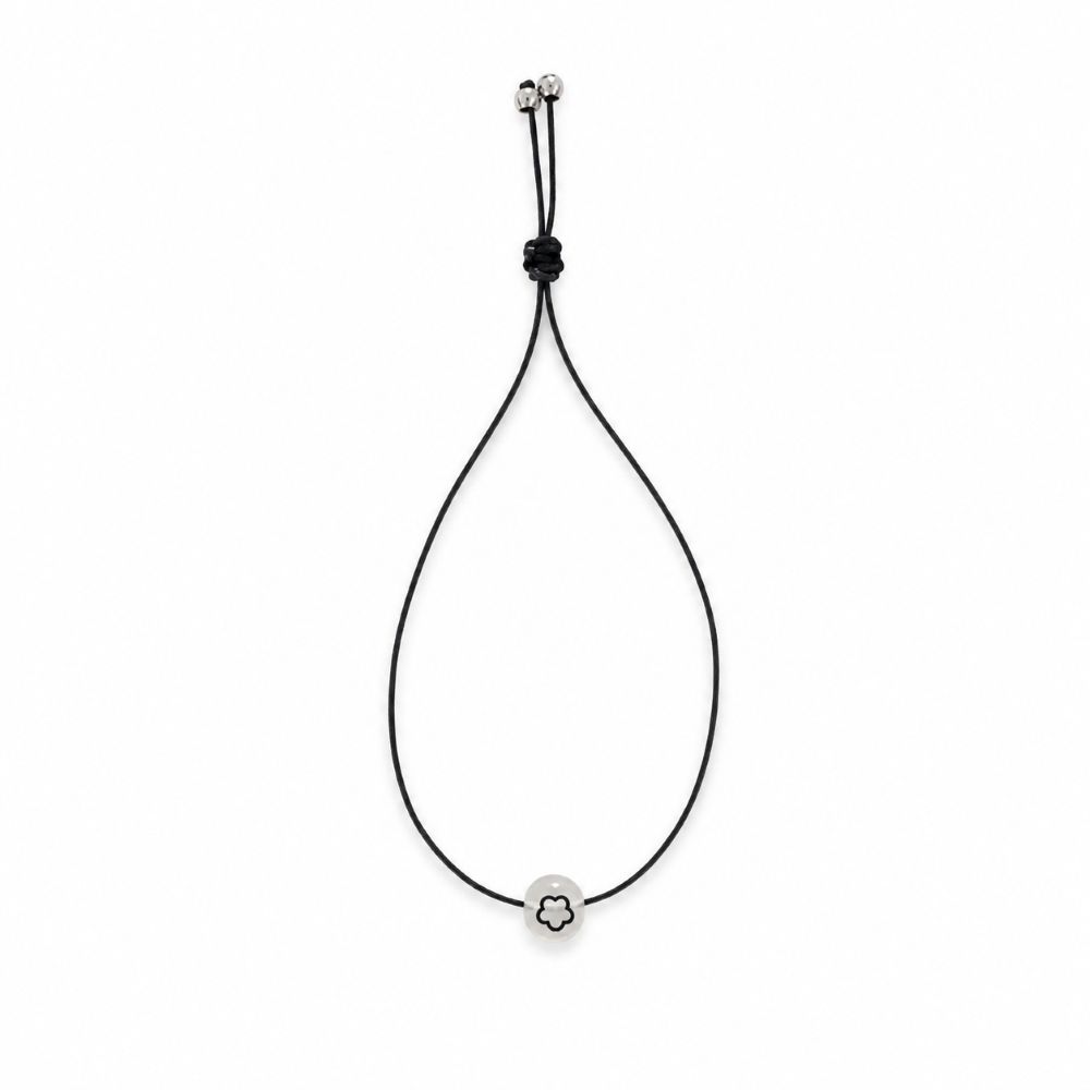 Bracelet enfant Fleur Lumineuse Faria Minia en acier inoxydable avec fleur phosphorescente et cordon ajustable.