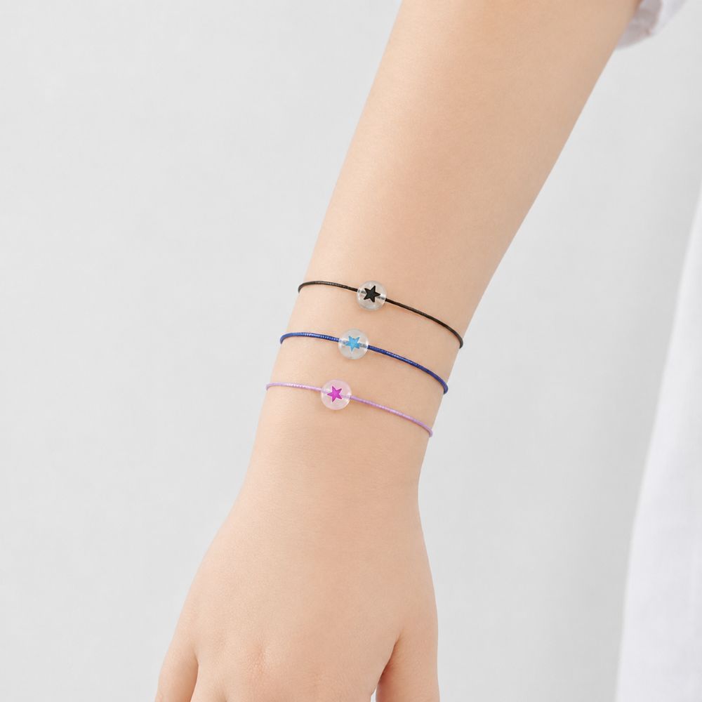 Bracelet enfant Étoile Lumineuse Eliza Minia en acier inoxydable avec étoile phosphorescente et cordon ajustable.