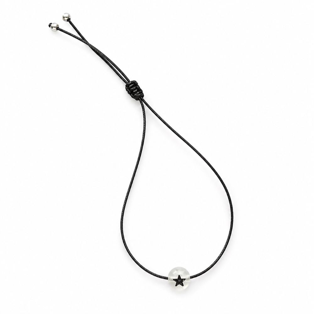 Bracelet enfant Étoile Lumineuse Eliza Minia en acier inoxydable avec étoile phosphorescente et cordon ajustable.