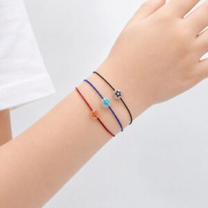 Bracelet enfant Étoile Lumineuse Eva Minia en acier inoxydable avec étoile phosphorescente et cordon ajustable.