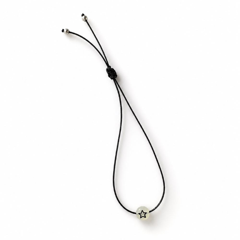 Bracelet enfant Étoile Lumineuse Eva Minia en acier inoxydable avec étoile phosphorescente et cordon ajustable.